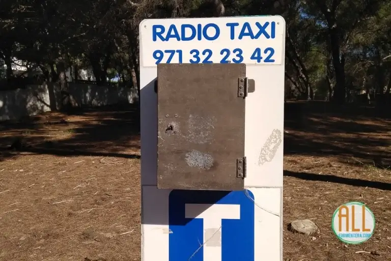 Señal de la la parada de taxis de Es Pujols con el texto Radio Taxi y el teléfono 972 32 23 42