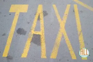 Letras de "Taxi" pintadas en el suelo con pintura amarilla
