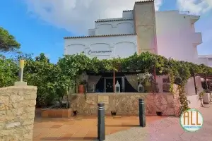Bâtiment extérieur de l'hôtel Entrepinos. Au premier plan, la terrasse couverte avec une vigne pour l'ombre.