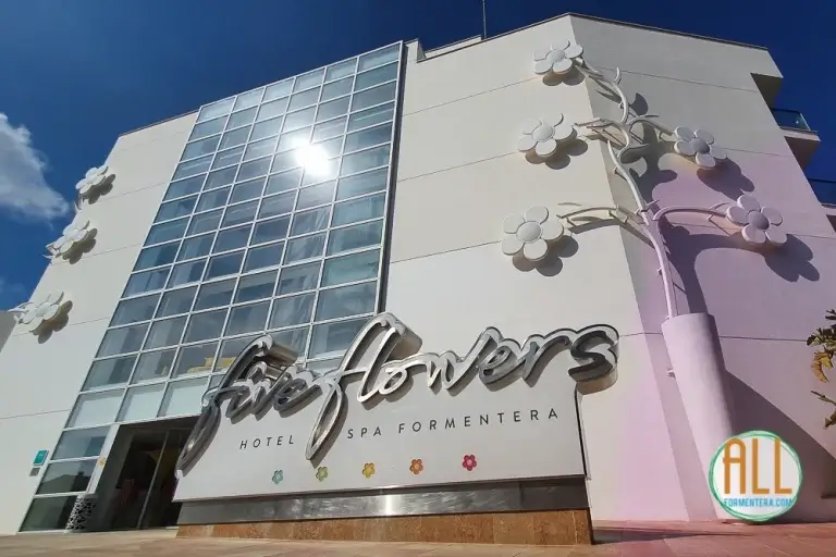 Vue extérieure du bâtiment de l'hôtel Five Flowers Formentera, avec le logo de l'hôtel au premier plan