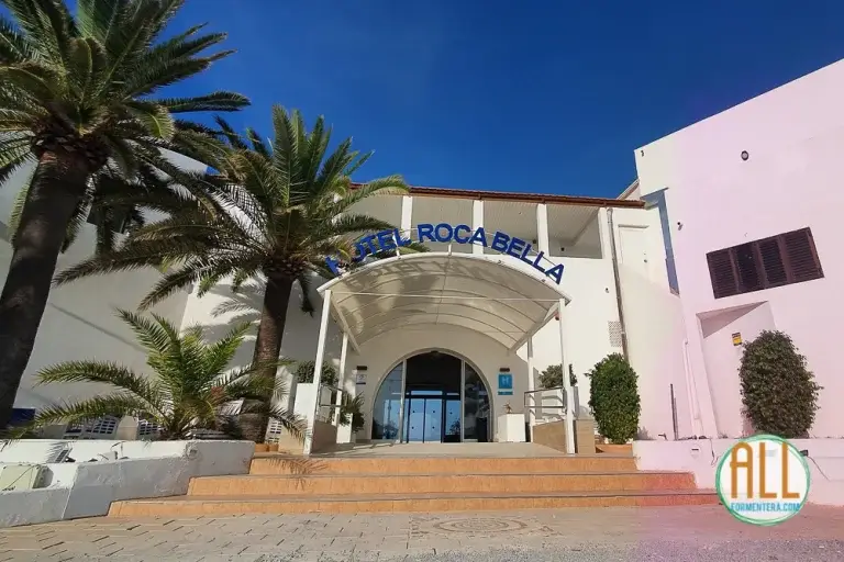 Entrada del hotel Roca Bella Formentera con las escaleras en primer término y dos palmeras en el lado izquierdo