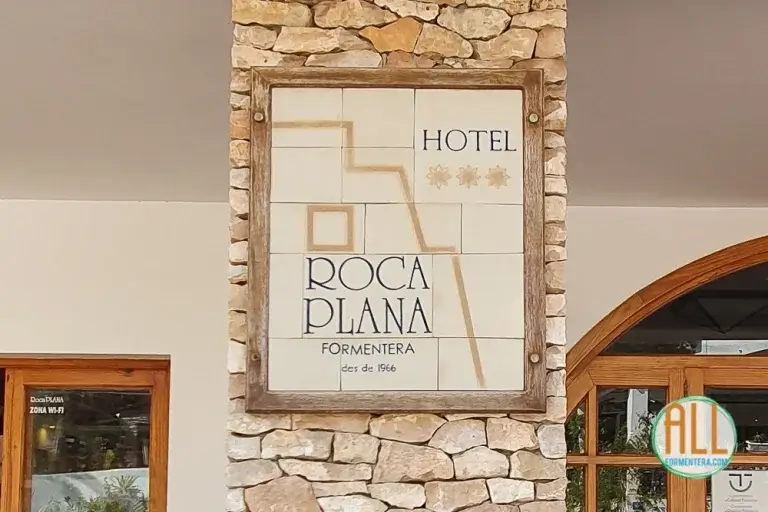 Logotipo del hotel Roca Plana Formentera con el nombre del hotel grabado en baldosas cerámicas y situado en un pilar del edificio
