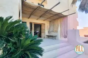 Vue de l'entrée de l'hôtel Casa Formentera, avec un palmier sur le côté gauche et trois marches d'accès.